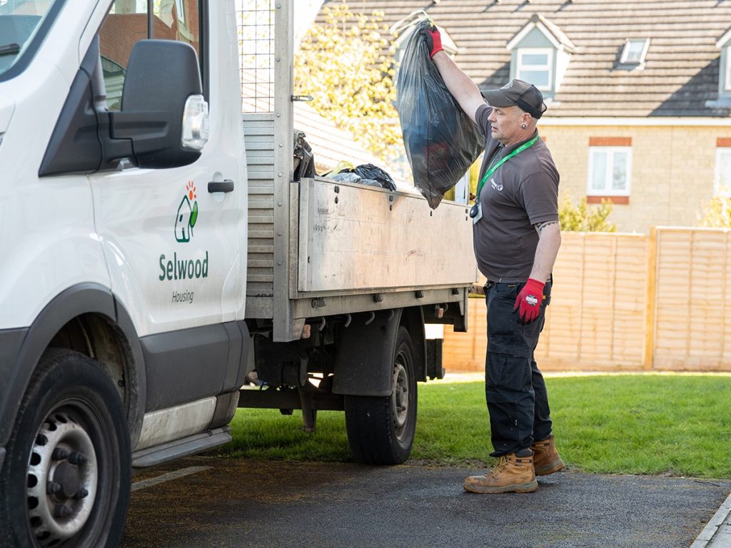 Selwood Housing neighbourhood caretaker Lance throwing bin bag into Selwood Housing van