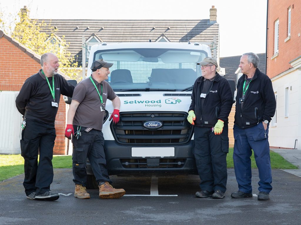 Neighbourhood careraking team at Selwood Housing standing in front of van chatting and laughing