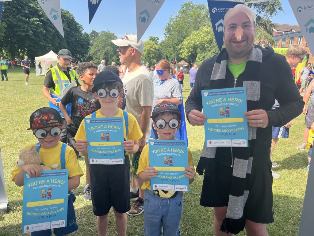 Trowbridge heroes and villains fun run minions fancy dress posing with certificates