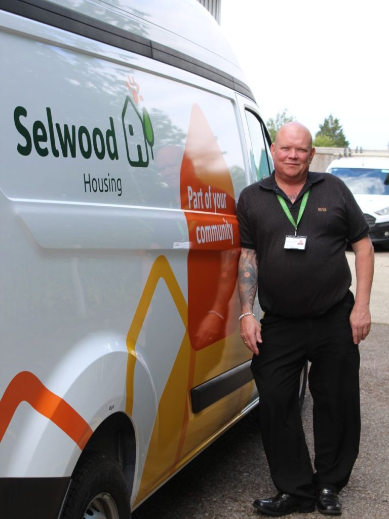 Jason Morris looking at the camera, leaning against a Selwood Housing van.