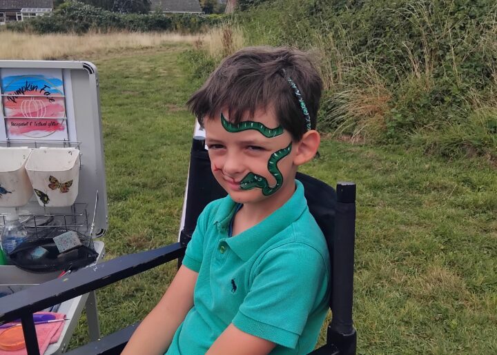 A boy with a snake face painting