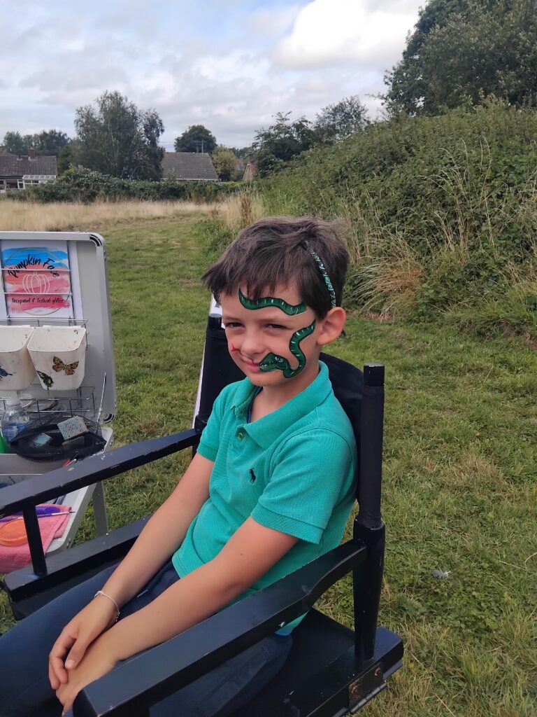 A boy with a snake face painting