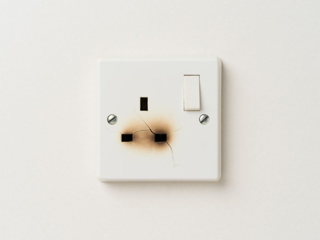 burnt plug socket on a white wall