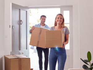 Young couple moving into a new home holding boxes