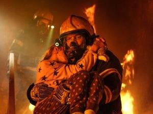 Fireman carrying girl from a fire