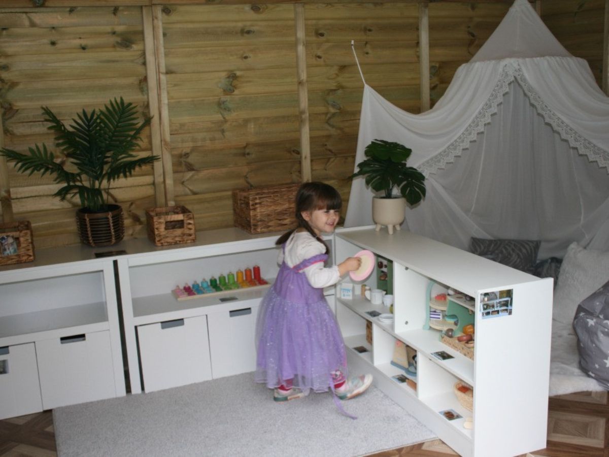 Young child plays in a montessori style area in a nursery setting