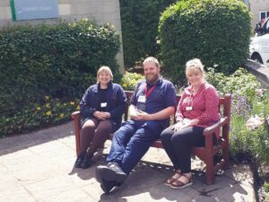 Three employees sat down on a bench outside